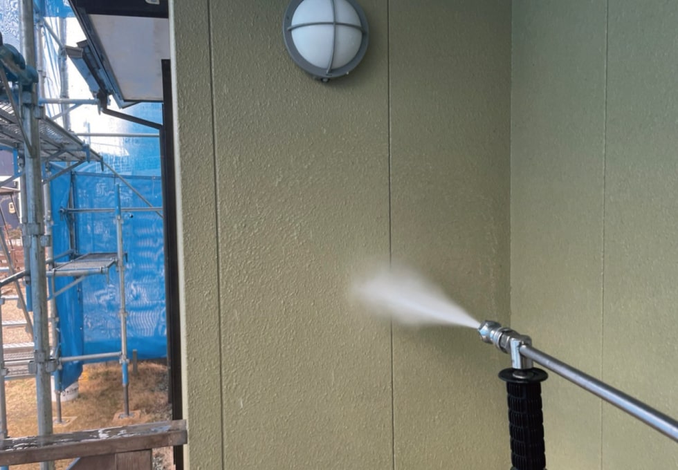 ベージュの外壁を高圧洗浄する様子（岩沼市SY様低）