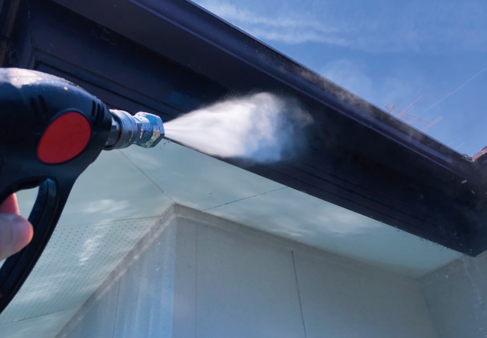 T様邸、軒天を高圧洗浄する様子